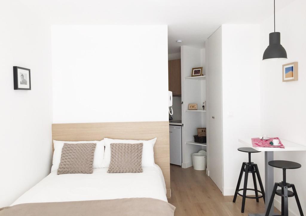 grand lit dans un studio meublé moderne
